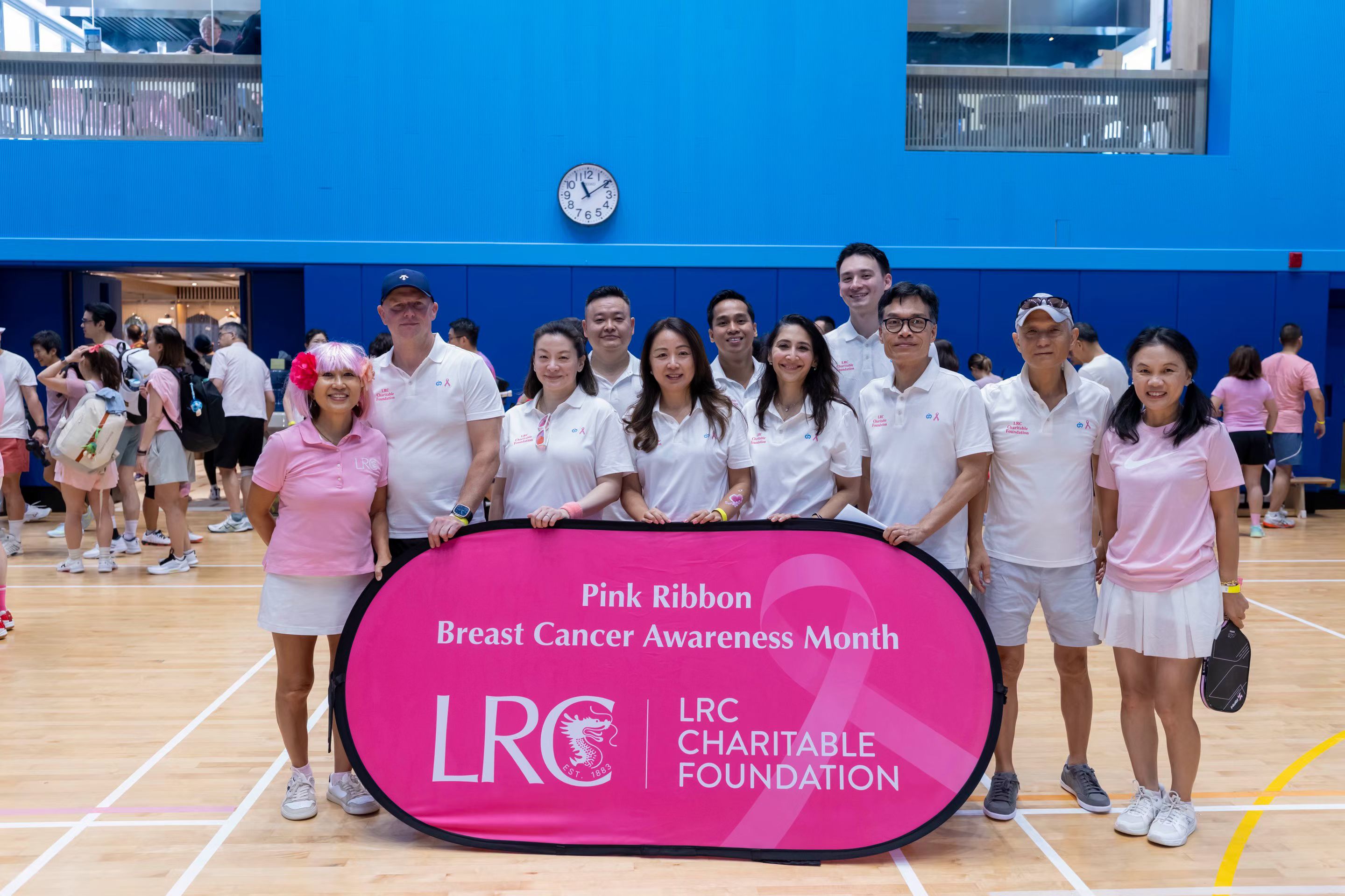 Owner-provided event photograph showing Pink Ribbon Breast Cancer Awareness Month signage and event participants.
